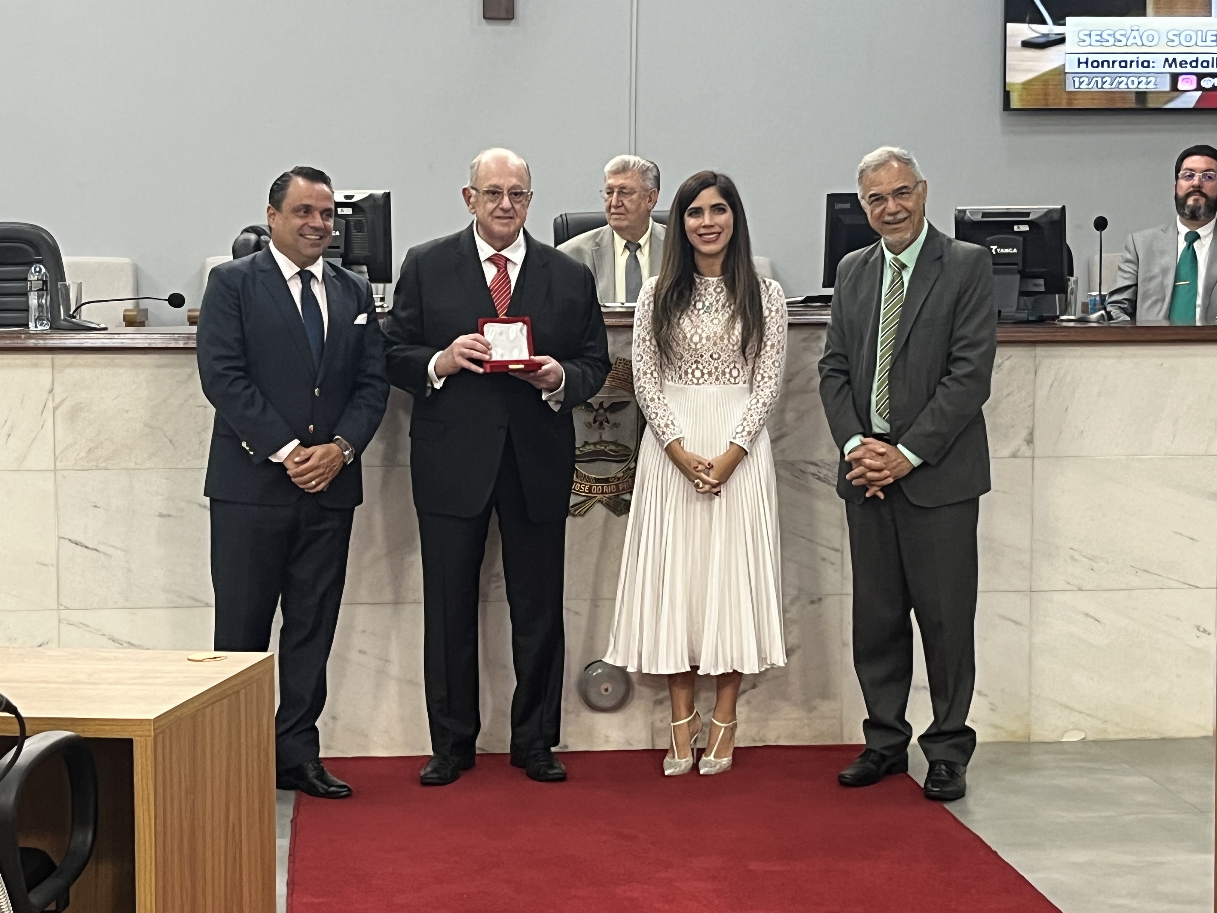 Halim Atique Júnior recebe a medalha das mãos de Jean Dornelas, acompanhado da esposa e do presidente da Câmara